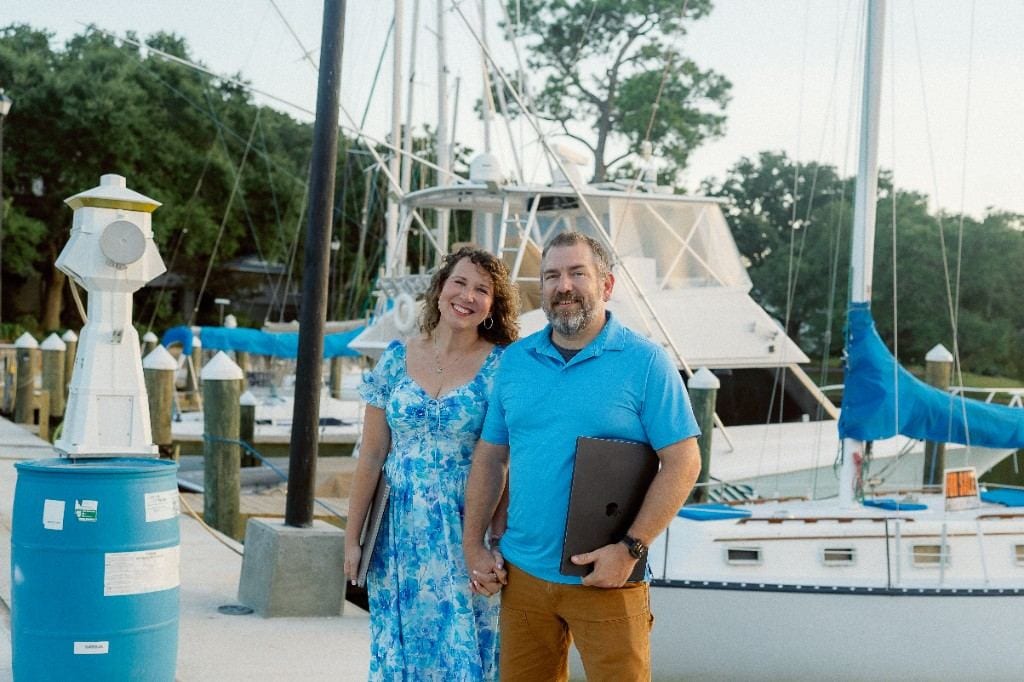 Anna and Bryan Cirlot on a Gulf Coast marina dock with laptops