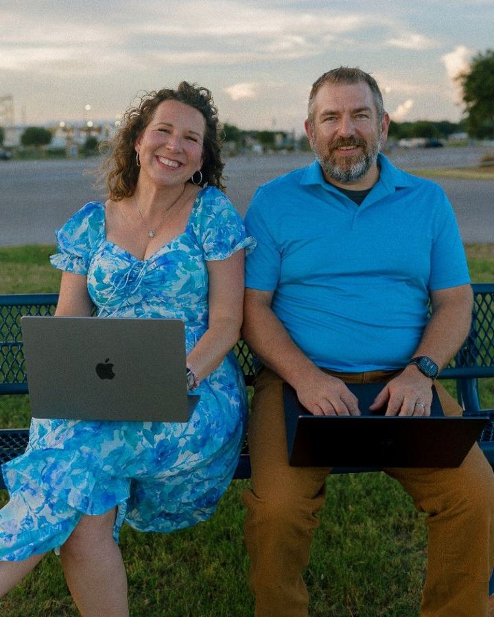 Anna and Bryan Cirlot on a park bench working on laptops
